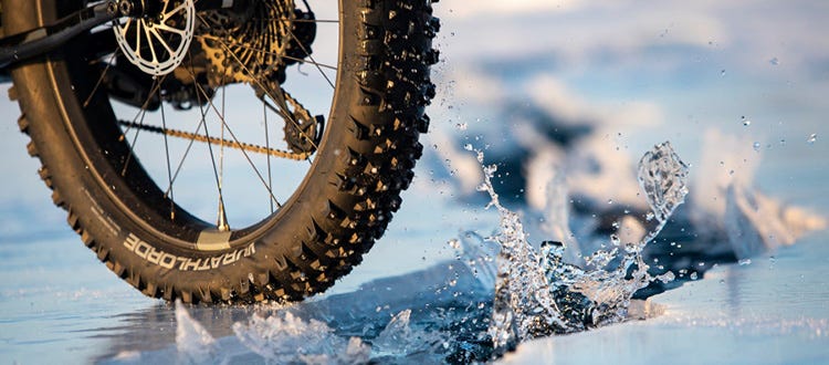 Un pneu à clous de vélo sur la glace qui se brise