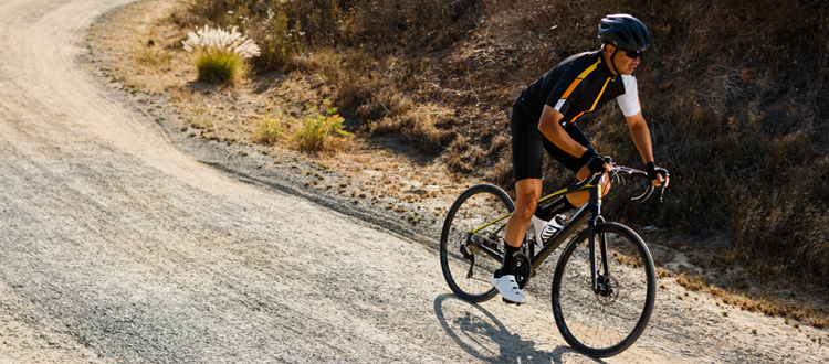 Cycliste en action dans un chemin de gravel sur un vélo noir